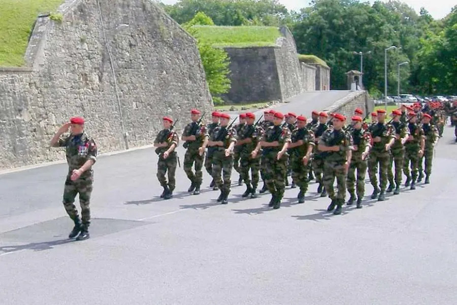 Une section défile au pas, encadrée par un officier