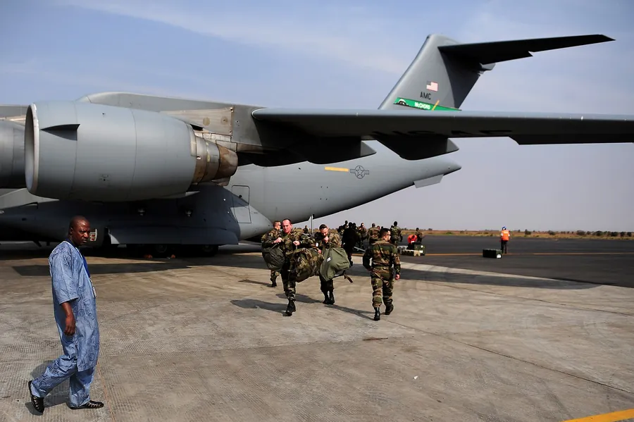 Des militaires chargent leur paquetage au pied d'un avion de transport