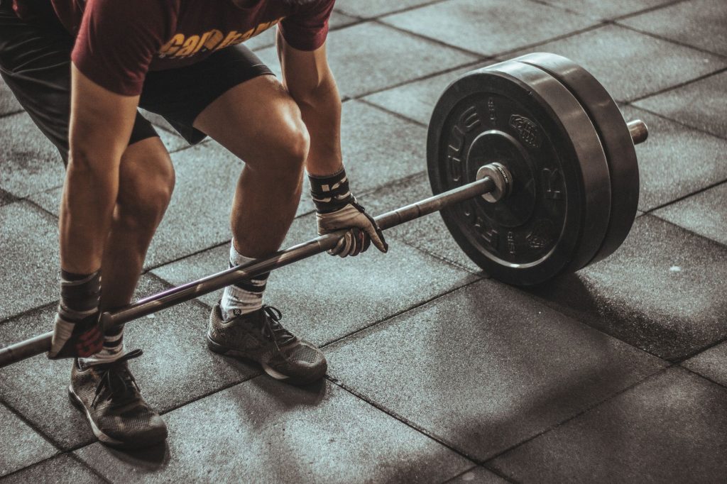 Un haltérophile concentré s'apprête à soulever une barre lourde dans une salle de sport