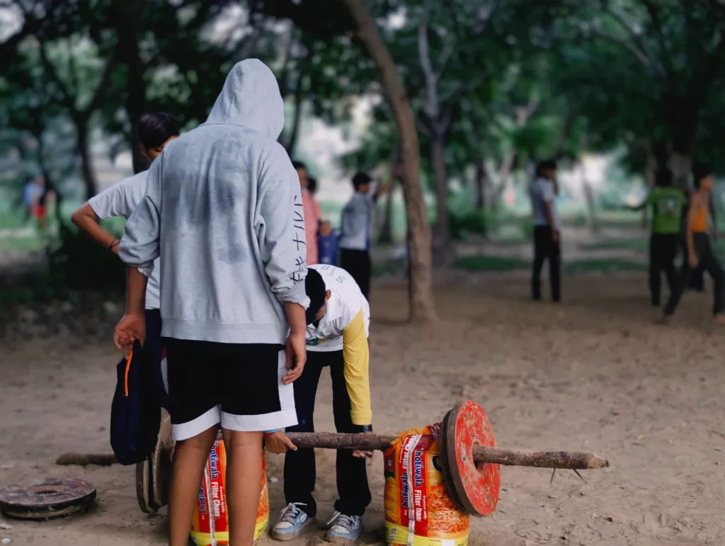 Groupe d'adolescents s'entraînant avec des poids improvisés dans un parc, en pleine action